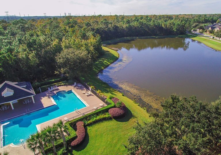 vue du ciel d'une villa avec piscine proche d'un lac