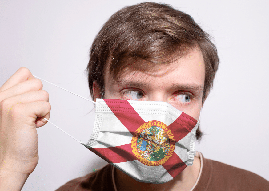 Un homme porte un masque avec les couleurs du drapeau de Floride